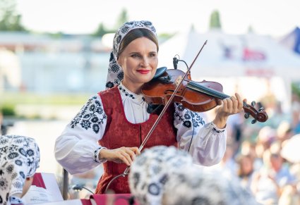 Zbliżenie na Skrzypaczkę w kostiumie wilanowskim grającą na instrumencie