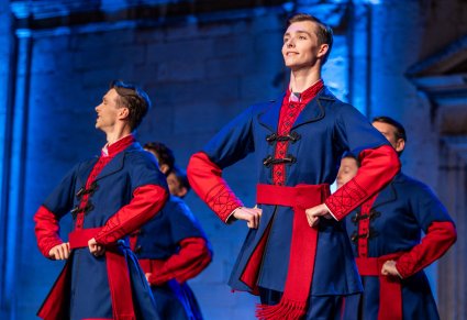 Zbliżenie na Artystów w kostiumach kujawskich na scenie w trakcie wykonywania choreografii tanecznej