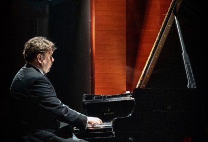 Zbliżenie na pianistę grającego na fortepianie