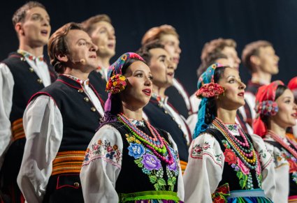 Zbliżenie na Artystów Chóru w kostiumach łowickich w trakcie śpiewu