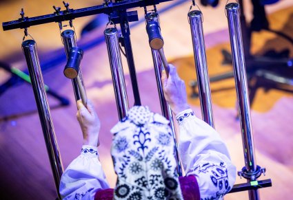 Zbliżenie na Muzyczkę w kostiumie wilanowskim grającą na instrumencie