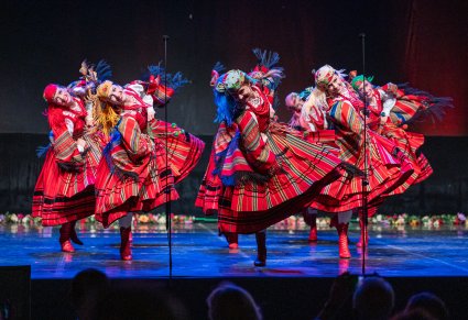 Artystki wykonujące choreografię taneczną na scenie w kostiumach sieradzkich