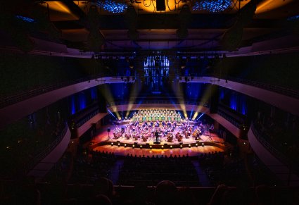 Widok na całą scenę Narodowego Forum Muzyki, a na niej Artyści Chóru w kostiumach łowickich wraz z Orkiestrą w kostiumach wilanowskich
