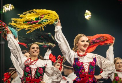 Zbliżenie na Artystki w kostiumach podhalańskich w trakcie wykonywania choreografii tanecznej