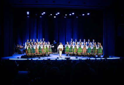 Na scenie, na środku widoczny solista w kostiumie podhalańskich, po jego bokach grupa Artystów Chóru w kostiumach łowickich, w tle widoczna Orkiestra z Dyrygentem