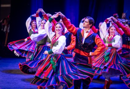 Pary Artystów z zespołu "Mazowsze" w kostiumach sannickich podczas wykonywania choreografii tanecznej na scenie