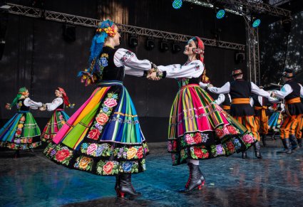Pary Artystek w kostiumach łowickich podczas wykonywania choreografii tanecznej