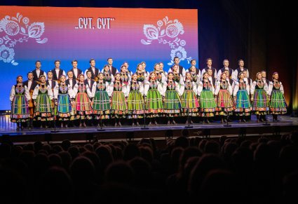 Na scenie Artyści chóru w kostiumach łowickich w trakcie śpiewu