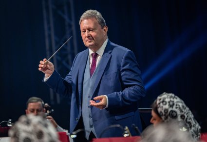 Zbliżenie na Dyrygenta trzymającego w ręku batutę