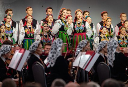Solistki chóru podczas wykonywania "Dwóch serduszek" w tle chór w kostiumach łowickich, poniżej część orkiestry w kostiumach wilanowskich