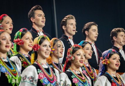 Zbliżenie na Artystów Chóru w kostiumach łowickich podczas śpiewu