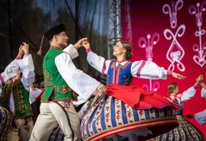 Zbliżenie na pary Artystów w kostiumach spiskich w trakcie wykonywania choreografii tanecznej