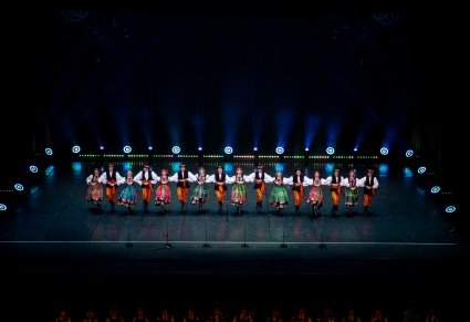 Na scenie Artyści w kostiumach łowickich podczas wykonywania choreografii tanecznej