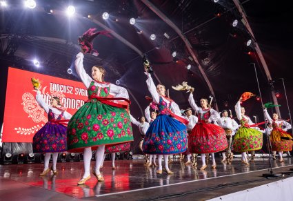 Na scenie Artystki w kostiumach podhalańskich kręcące się w koło i machające w górze chustami