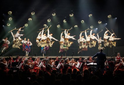Na scenie Artyści w kostiumach podhalańskich w trakcie wykonywania imponującej choreografii tanecznej, niżej Orkiestra w kostiumach wilanowskich wraz z Dyrygentem