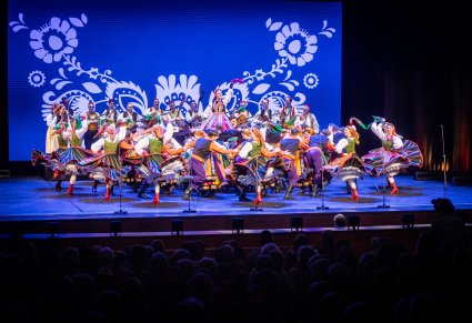 Artyści zespołu "Mazowsze" w kostiumach ludowych podczas wykonywania choreografii tanecznej na scenie