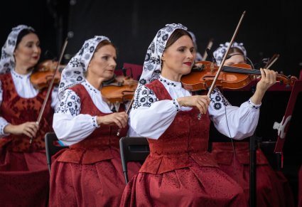 Zbliżenie na Artystki orkiestry w kostiumach wilanowskich w trakcie gry na instrumentach smyczkowych