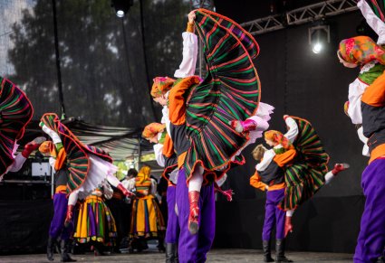 Pary Artystów w kostiumach sannickich podczas wykonywania choreografii tanecznej na scenie