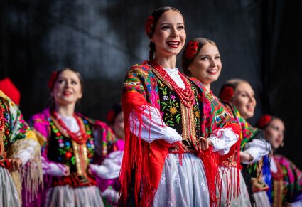 Zbliżenie na uśmiechnięte Artystki w kostiumach krakowskich na scenie