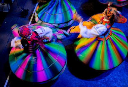 Zbliżenie z góry na Artystki zespołu "Mazowsze" w kostiumach ludowych, kręcące się w koło na scenie