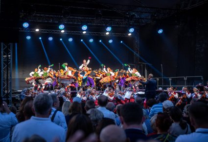 Artyści w choreografii w kostiumach sannickich widoczna publiczność