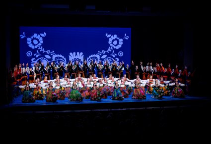 Artyści zespołu "Mazowsze" w kostiumach ludowych podczas wykonywania choreografii tanecznej na scenie