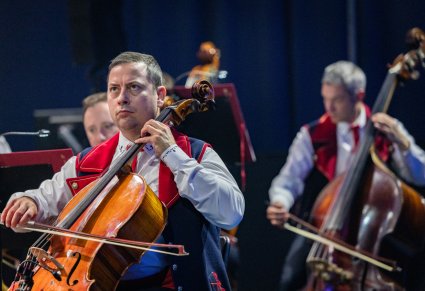 Zbliżenie na trzech Artystów Orkiestry w kostiumach wilanowskich podczas gry na instrumentach smyczkowych
