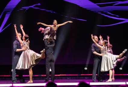 Na scenie Artyści w kostiumach współczesnych wykonujący choreografię taneczną do utworu Medley