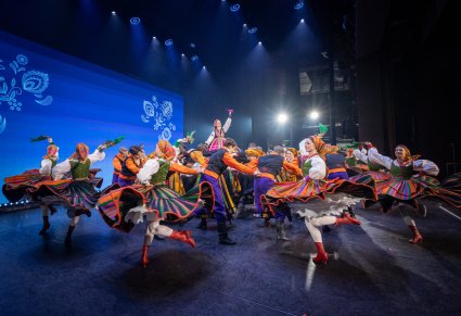 Na scenie Artyści w kostiumach ludowych podczas wykonywania choreografii tanecznej