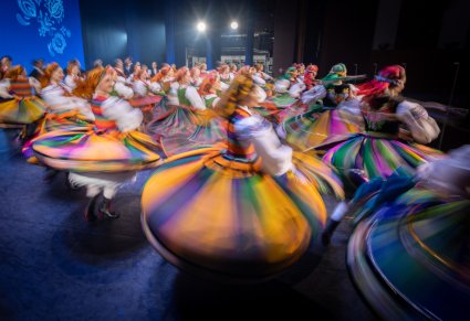 Na scenie Artystki w kostiumach ludowych podczas wykonywania obrotów
