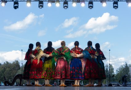 Widok na Artystki w kostiumach podhalańskich na scenie zwrócone w stronę publiczności