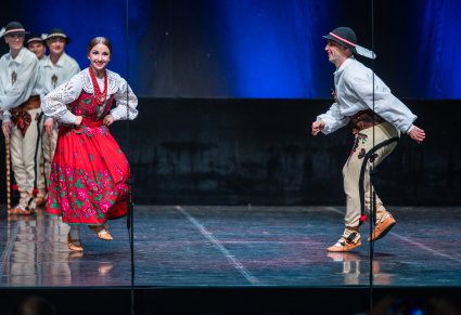 Artyści w trakcie wykonywania choreografii na scenie w kostiumach podhalańskich