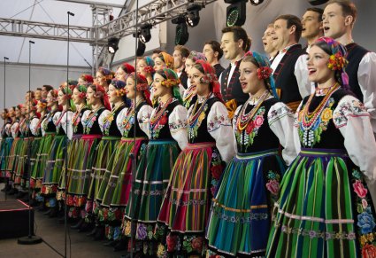Widok z boku sceny na chór w kostiumach łowickich