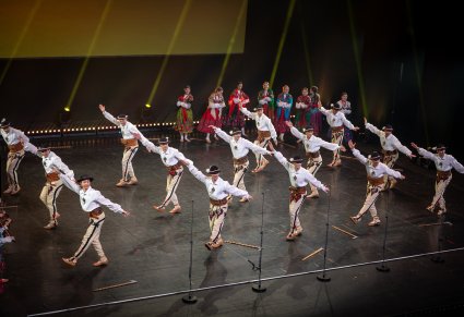 Grupa Artystów w kostiumach podhalańskich wykonująca choreografię taneczną