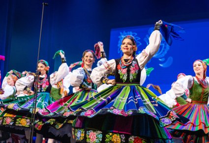 Zbliżenie na Artystki w kostiumach łowickich i sannickich w trakcie wykonywania finałowej choreografii tanecznej