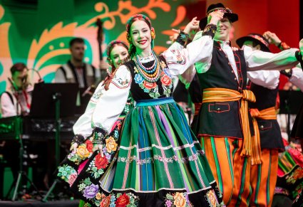 Zbliżenie na artystkę w kostiumie łowickim w układzie finałowym