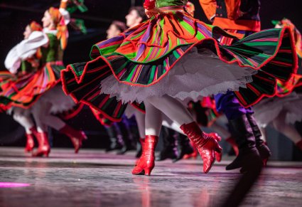Zblizenie na nogi i spódnice tancerek na scenie. Tancerki w kostiumach sannickich
