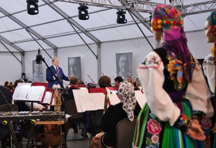 Widok zza części chóru na dyrygującego Dyrektora zespołu i częśc orkiestry w kostiumach wilanowskich