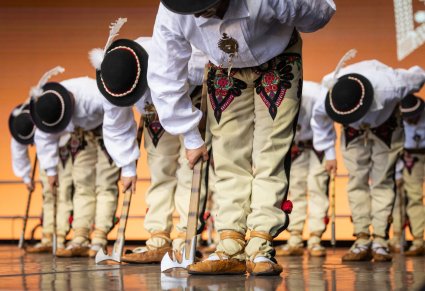 Zbliżenie na Artystów w kostiumach podhalańskich w trakcie wykonywania choreografii tanecznej