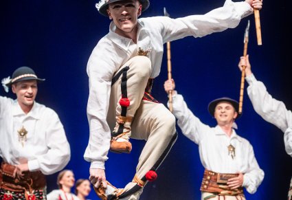 Artyści wykonujący choreografię taneczną na scenie w kostiumach podhalańskich