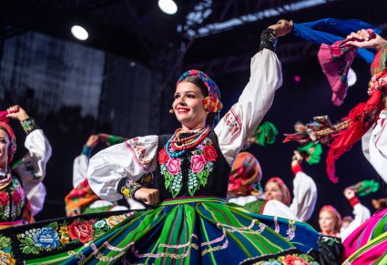 Tancerka w kostiumie łowickim na scenie w czasie tańca