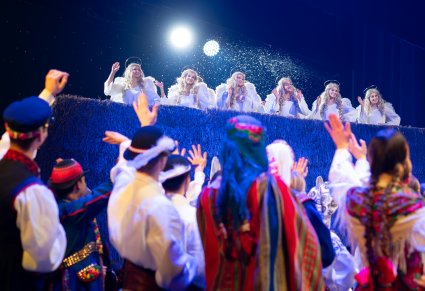 Artyści w kostiumach regionalnych zwróceni w stronę Aniołów Dachowych