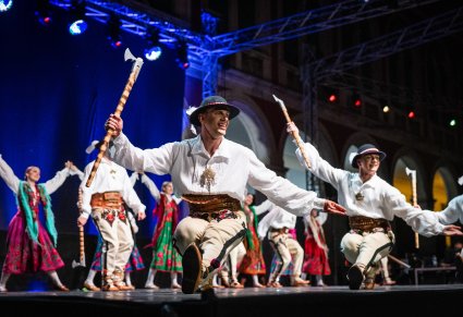 Artyści w trakcie wykonywania choreografii na scenie w kostiumach podhalańskich