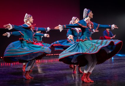 Grupa Artystów w kostiumach kujawskich w trakcie wykonywania choreografii tanecznej