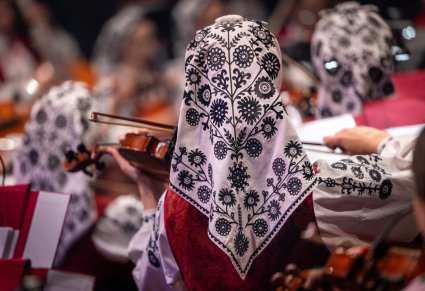 Zbliżenie na chustę wilanowską znajdującą się na głowie u skrzypaczki z orkiestry