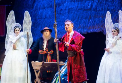 Zbliżenie na Kosyniera a w tle Maryja, Józef i Anioły