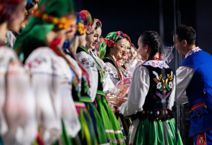 Zbliżenie na moment przekazywania upominków od Organizatora dla Artystów Chóru