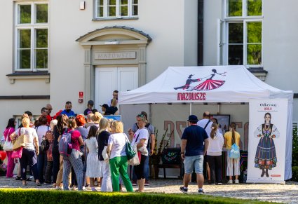 Zwiedzający ustawieni pod Pałacem Karolin