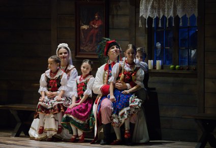 Zbliżenie na Parę Młodą, która trzyma na kolanach dzieci w kostiumach krakowskich