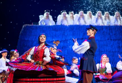 Zbliżenie na Artystów w kostiumach regionalnych wykonujący finałową choreografię